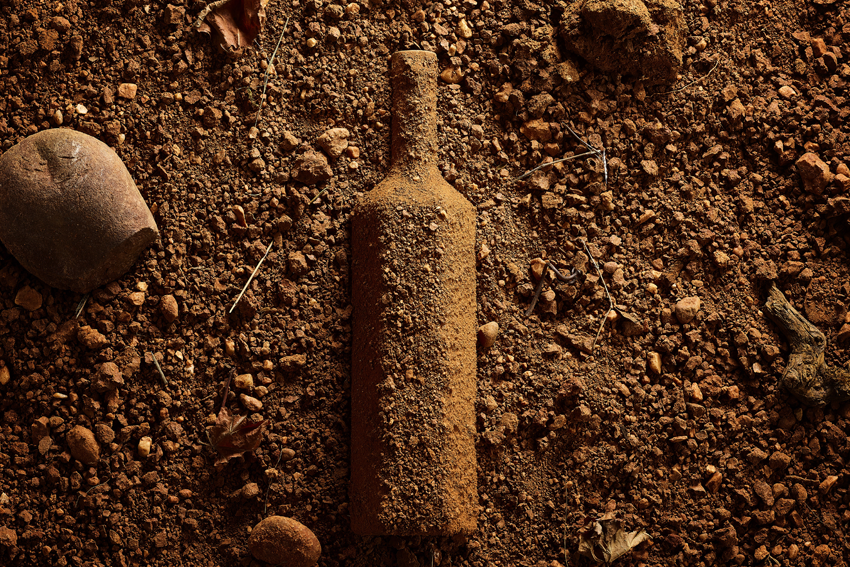 Eine Flasche vom Rosewein Gasier verdeckt von der dortigen Erde