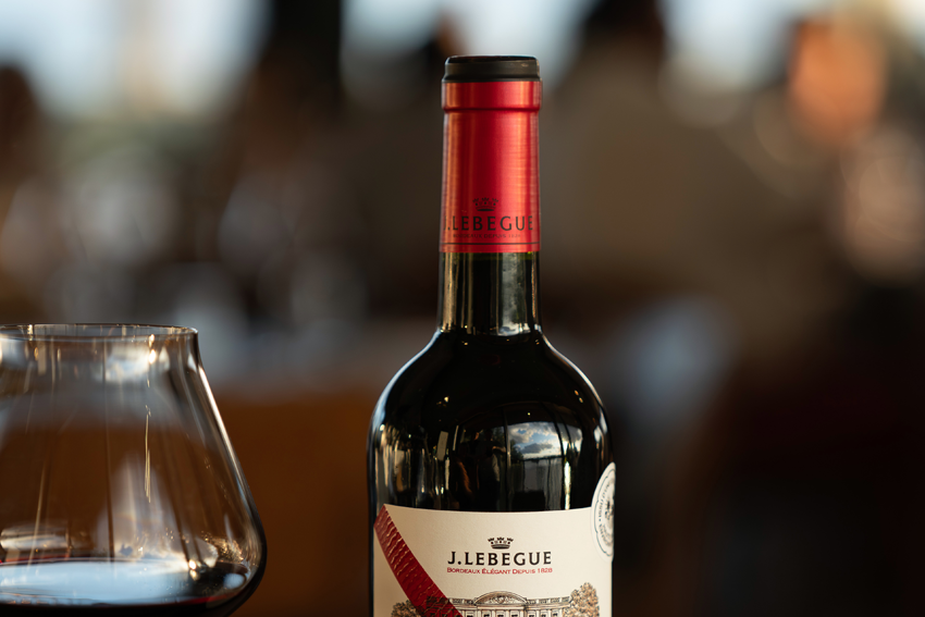 eine Flasche Bordeaux Rouge von j. Lebegue, daneben ein Glas mit Rotwein gefüllt.